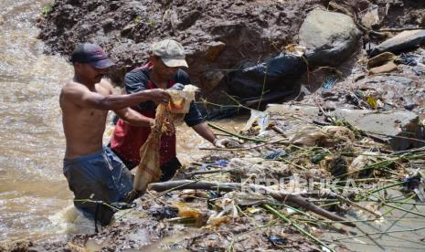 Pekerja berupaya mengangkat sampah yang menyumbat saluran air di kawasan Kolam Retensi Cisanggarung, Kecamatan Mandalajati, Kota Bandung, Selasa (20/12/2022). Kolam retensi yang dibangun di atas lahan sekitar 1,2 hektare ini berkapasitas 6.000 meter kubik air. Kolam ini diharapkan bisa berfungsi menahan air yang menjadi potensi banjir di wilayah Arcamanik dan sekitarnya.