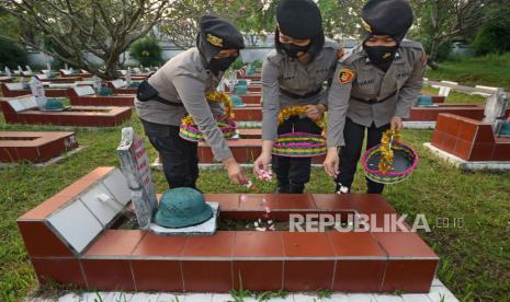 Tiga anggota Polwan menabur bunga di salah satu taman makam pahlawan dalam rangka memperingati Hari Bhayangkara. (ilustrasi)