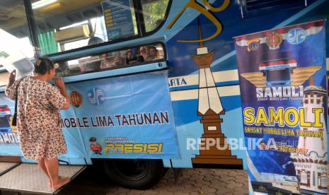 Warga membayar pajak kendaraan lima tahunan di Layanan Mobil Keliling Samsat Mobile Lima Tahunan (Samoli) di Pakualaman, Yogyakarta, Kamis (13/7/2023). Ditlantas Polda DIY membuat terobosan baru perpanjangan STNK lima tahunan dan pembayaran pajak kendaraan bermotor atau mobil melalui layanan keliling Samoli. Layanan Samoli ini untuk mempermudah masyarakat melakukan pembayaran pajak lima tahun tanpa harus ke kantor  Samsat. Layanan baru tersedia satu mobil dan berganti tempat setiap hari mulai dari Purawisata, Lapangan Minggiran, XT Square, Pura Pakualaman, dan Kantor LPP.