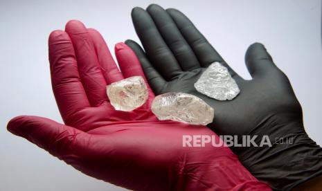  Seorang karyawan menunjukkan batu berkualitas permata, termasuk berlian kasar 242 karat langka yang akan ditawarkan pada lelang internasional ke-100 produsen berlian Alrosa yang dikendalikan negara Rusia, selama presentasi di Moskow, Rusia, 25 Februari 2021. Berlian itu satu dari batu kualitas permata terbesar yang ditambang Alrosa abad ini, kata perusahaan itu. Gambar diambil 25 Februari 2021. 