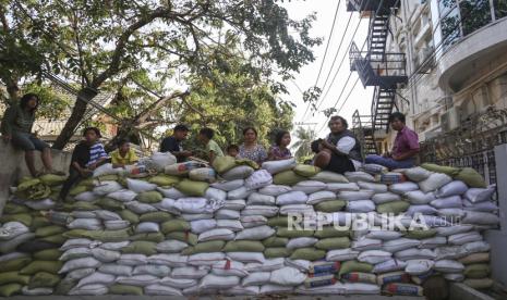 Orang-orang duduk di pembatas jalan darurat yang dibangun untuk mencegah pasukan keamanan memasuki daerah di Mandalay, Myanmar, 5 Maret 2021. Protes antikudeta terus berlanjut pada 05 Maret meskipun tindakan keras terhadap demonstran semakin meningkat oleh pasukan keamanan. Lebih dari 50 orang tewas dalam tindakan keras oleh pasukan keamanan sejak kudeta militer pada 1 Februari 2021.