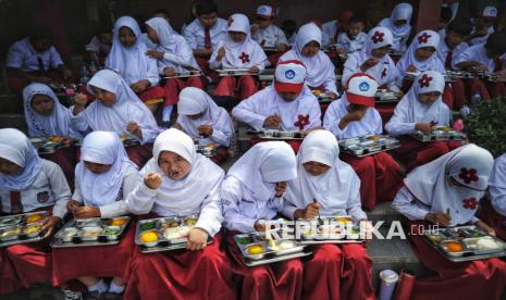 Para siswa menyantap hidangan Makan Bergizi Gratis (MBG) di SDN 05 Sukatani, Depok, Jawa Barat, Senin (6/1/2025). Pada hari pertama program makan bergizi gratis (MBG) tersebut para siswa terlihat antusias menikmati menu makanan. Total sebanyak 406 para siswa kelas 1 hingga kelas 6 menikmati paket menu makanan uang teridiri dari Nasi, Daging Ayam, Tempe, Sayur Buncis dan Buah Jeruk. Salah satu siswa kelas 5 Fatah Ar Rozak mengaku senang mendapatkan makan bergizi gratis dari program pemerintah tersebut. Menurutnya rasa makanannya enak dan untuk porsi makanannya cukup mengenyangkan.