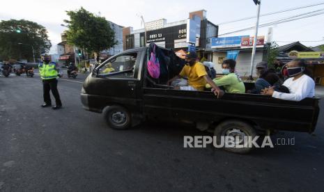 Personel Satlantas Polresta Denpasar menghentikan mobil bak terbuka berisi warga yang hendak berwisata (ilustrasi) 