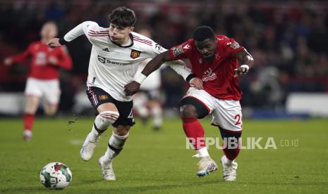 Alejandro Garnacho dibayangi Serge Aurier menggiring bola pada laga semi-final Piala Liga antara Nottingham Forest melawan Manchester United di Stadion City Ground, Nottingham, Inggris, Kamis (26/1/2023) dini hari WIB.25 2023. (Tim Goode/PA via AP)