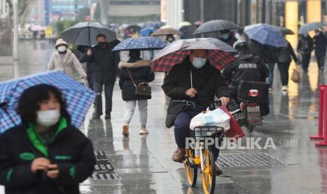 Warga yang mengenakan masker untuk membantu melindungi diri dari COVID-19 bergerak di sepanjang jalan di Wuhan di Provinsi Hubei, China tengah, Minggu, 23 Januari 2022. 