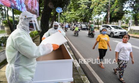 Jaktim Bangun Tugu Peti Mati Covid-19 di Seluruh Kecamatan. Petugas Suku Dinas Pertamanan dan Hutan Kota Jakarta Selatan menunjukkan peti mati dengan menggunakan APD di depan Taman Pemakaman Umum (TPU) Tanah Kusir, Jakarta. Kegiatan tersebut untuk menyosialisasikan pencegahan penyebaran Covid-19 yang dapat menyebabkan kematian. Ilustrasi