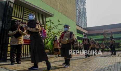 Sejumlah siswa pulang usai melaksanakan uji coba pembelajaran tatap muka tahap dua di SDN 08 Kenari, Jakarta, Rabu (9/6). Sebanyak 226 sekolah di Jakarta mengikuti uji coba pembelajaran tatap muka tahap dua dengan kuota 50 persen dari jumlah siswa dan tetap menerapkan protokol kesehatan. Republika/Putra M. Akbar