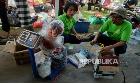 Petugas menimbang sampah anorganik di Bank Sampah Bumi Hijau, Balai RW Perumahan Cluster Verina, Kota Tangerang Selatan, Banten, Ahad (4/2/2024). Pengelolaan sampah anorganik dengan sistem tabungan bank sampah tersebut merupakan inisiasi warga yang didukung oleh Dinas Lingkungan Hidup Kota Tangerang Selatan, sebagai bentuk upaya penyadartahuan bagi warga terkait pengelolaan sampah secara berkelanjutan. Program tabungan bank sampah ini dimulai sejak Januari lalu dengan jumlah nasabah sebanyak 74 orang warga sekitar. Sampah yang dapat ditukar menjadi tabungan tersebut cukup beragam mulai dari sampah plastik, kaca, logam, minyak jelantah, besi, kertas hingga sampah elektronik. Hingga saat ini, Bank Sampah Bumi Hijau Perumahan Cluster Verina sudah berhasil mengumpulkan sampah anorganik seberat 2.1 ton yang nantinya akan dikelola di bank sampah Dinas Lingkungan Hidup Kota Tangerang.