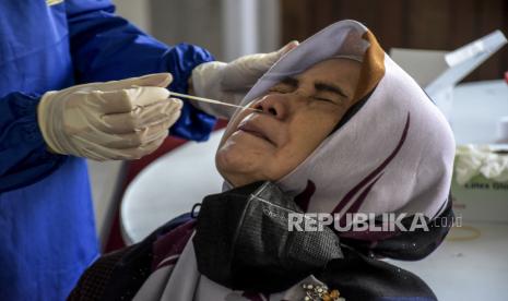 Petugas kesehatan melakukan tes usap PCR Covid-19 melalui hidung. Untuk cacar monyet, PCR dilakukan dengan mengusap ruam di tubuh.