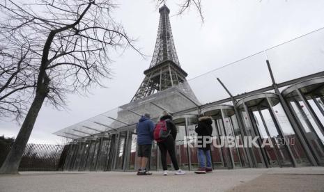 Visitors stand at the closed gates leading to the Eiffel Tower, Tuesday, Feb. 20, 2024 in Paris. Visitors to the Eiffel Tower were turned away for the second consecutive day because of a strike over poor financial management at one of the world