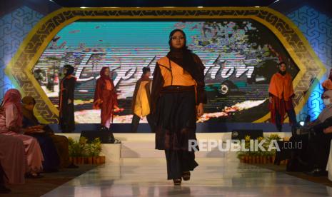 Model memperagakan busana muslim pada malam puncak pergelaran Fashion Show Aceh Sharia Festival 2021 secara virtual di Banda Aceh, Aceh, Sabtu (7/8). Makanan halal dan modest fashion menjadi bahasan utama dalam gelaran Indonesia Sharia Economic Festival (ISEF) 2021 yang digelar Bank Indonesia. 