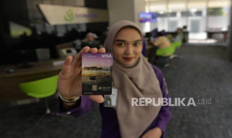 Karyawan menunjukkan kartu Shar-E Debit VISA Paywave di kantor cabang Muamalat Tower Jakarta, Jumat (26/4/2-24). Bank Muamalat merilis fitur terbaru dari kartu Shar-E Debit VISA yaitu teknologi nirsentuh atau contactless yang diberi nama Paywave. Fitur ini dapat dimanfaatkan oleh jemaah haji nasabah Bank Muamalat untuk bertransaksi di Tanah Suci.  Kartu ini bisa digunakan kapan saja pada mesin EDC yang mendukung fitur Paywave di luar negeri, termasuk di Arab Saudi untuk kebutuhan transaksi seperti pembayaran di merchant, pembelian buah tangan dan lain-lain. 