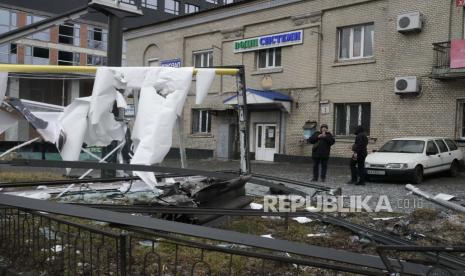  Seorang wanita mengambil foto akibat penembakan Rusia di Kyiv, Ukraina, Kamis, 24 Februari 2022. Direktur CIA William Burns pada Rabu (20/7/2022) memperkirakan, korban tewas akibat invasi Rusia di Ukraina telah mencapai sekitar 15 ribu orang