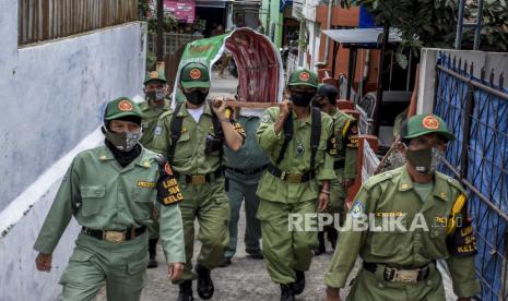 Petugas Linmas memanggul replika keranda mayat saat sosialisasi perpanjangan Pemberlakuan Pembatasan Kegiatan Masyarakat (PPKM) Skala Mikro di Cimahi Tengah, Kota Cimahi, Selasa (23/2). Pemerintah memperpanjang Pemberlakuan Pembatasan Kegiatan Masyarakat (PPKM) Skala Mikro di Jawa dan Bali meliputi 123 kabupaten/kota di tujuh provinsi yakni DKI Jakarta, Banten, Jawa Barat, Jawa Tengah, Jawa Timur, DI Yogyakarta dan Bali mulai 23 Februari hingga 8 Maret guna menekan laju kasus serta mencegah penyebaran Covid-19 di tingkat desa atau kelurahan. Foto: Abdan Syakura/Republika