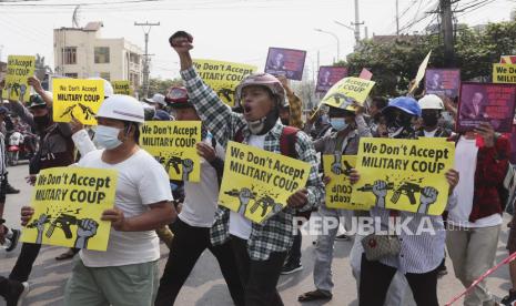  Pengunjuk rasa anti-kudeta memegang tanda-tanda yang bertuliskan 