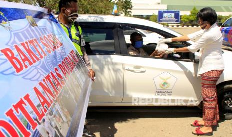 Seorang personel Polwan dari Ditlantas Polda NTT memberikan nasi bungkus kepada sopir taksi bandara di Bandara El Tari Kupang, NTT,Selasa (21/4/2020). Sebanyak 250 nasi bungkus dibagi-bagikan oleh Polwan di Polda NTT kepada warga terdampak COVID-19 dalam rangka memperingati Hari Kartini