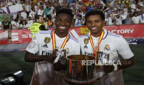 Pemain penyerang Real Madrid Vinicius Junior (kiri) dan Rodrygo Goes (kanan) berpose dengan trofi setelah pertandingan final sepak bola Copa del Rey antara Real Madrid dan Osasuna di Stadion La Cartuja di Sevilla, Spanyol, Ahad (7/5/2023) dini hari WIB. Rodrygo Goes menjadi pahlawan kemenangan Real Madrid saat membungkam Osasuna, 2-1, di partai final Copa del Rey, Ahad (7/5/2023) dini hari WIB. 