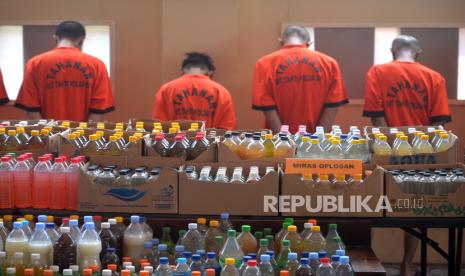 Tersangka dan barang bukti ratusan botol minuman oplosan ditampilkan saat rilis kasus peredaran narkotika, miras dan obat berbahaya di Polda Daerah Istimewa Yogyakarta, Rabu (15/11/2023). Dalam kurun waktu Oktober hingga November 2203, Polda DIY berhasil mengungkap delapan kasus peredaran narkotika, miras, dan obat berbahaya. Sebanyak sembilan tersangka berhasil diamankan dengan total barang bukti ganja seberat 725,54 gram, dan sabu 2,47 gram. Kemudian obat berbahaya (Obaya) jenis Trihexypenidyl (pil sapi) sebanyak 5.545 butir, dan 2.046 botol miras oplosan. Tersangka nantinya dijerat dengan pasal yang berbeda, salah satunya dengan hukuman maksimal 12 tahun penjara.