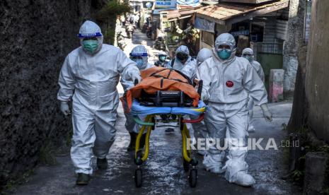 Petugas Public Safety Center 119 (PSC 119) bersama petugas puskesmas mengevakuasi jenazah pasien Covid-19 yang meninggal saat isolasi mandiri (isoman) di rumahnya di Jalan Cibarengkok, Sukajadi, Kota Bandung, Ahad (18/7).  -foto ilustrasi-