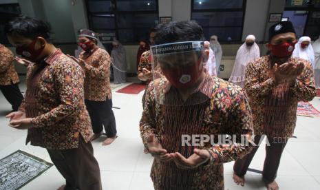 Sejumlah guru berdoa usai melaksanakan shalat ghaib saat penutupan Masa Pengenalan Lingkungan Sekolah (MPLS) di SD Muhammadiyah 11, Surabaya, Jawa Timur, Rabu (15/7/2020). Penutupan MPLS di sekolah tersebut diisi dengan pelaksanaan shalat ghaib untuk mendoakan salah satu wali murid yang meninggal akibat Covid-19. Mulai Senin (23/11), guru SD-SMP di Surabaya kembali berkantor di sekolah.