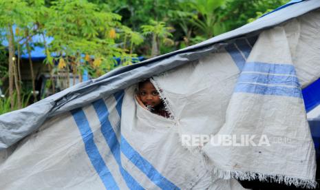 Seorang anak melihat keluar dari balik tenda pengungsian di Stadion Manakarra, Mamuju  Sulawesi Barat, Jumat (29/1/20 21). Gubernur Sulbar memutuskan perpanjangan status keadaan tanggap darurat bencana gempa bumi Sulbar selama 7 hari kedepan, terhitung tanggal 29 Januari  hingga 4 Februari mendatang. 