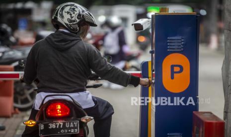 Pengendara sepeda motor mengambil karcis parkir di lapangan IRTI Monas, Jakarta Pusat, Jakarta, Rabu (23/6/2021). Pemerintah Provinsi DKI Jakarta berencana menaikkan tarif layanan parkir dengan tarif tertinggi Rp60 ribu per jam untuk mobil dan Rp18 ribu per jam untuk motor yang bertujuan mendorong warga Jakarta beralih menggunakan transportasi umum. 