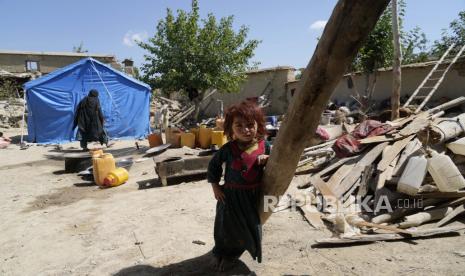  Gadis Afganistan berdiri di halaman rumahnya yang hancur setelah gempa bumi di distrik Gayan di provinsi Paktika, Afganistan, Ahad, 26 Juni 2022. Gempa kuat melanda wilayah pegunungan berbatu di Afganistan timur Rabu pagi, meratakan batu dan bata lumpur. rumah di gempa paling mematikan di negara itu dalam dua dekade, kantor berita pemerintah melaporkan.