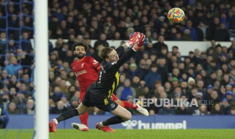 Striker Liverpool Mohamed Salah (kiri) mencetak gol kedua melewati kiper Everton Jordan Pickford selama pertandingan sepak bola Liga Primer Inggris antara Everton dan Liverpool di Goodison Park di Liverpool, Inggris, Rabu, 1 Desember 2021. Liverpool unggul 4-1 atas Everton.