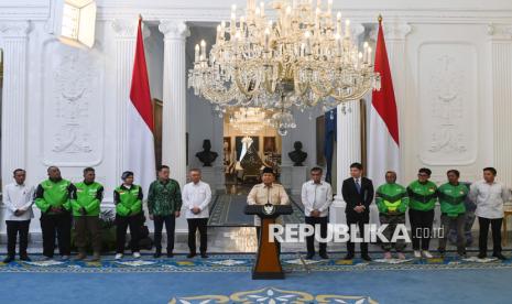 Presiden Prabowo Subianto (tengah) didampingi Mensesneg Prasetyo Hadi (kiri), Menhub Dudy Purwagandhi (keenam kiri), Menaker Yussierli (keenam kanan), Seskab Teddy Indra Wijaya (kanan), CEO Gojek Patrick Walujo (kelima kiri) dan CEO Grab Anthony Tan (kelima kanan) serta perwakilan pengemudi ojek daring menyampaikan keterangan terkait pemberian tunjangan hari raya (THR) di Istana Merdeka, Jakarta, Senin (10/3/2025). Presiden Prabowo mengumumkan pengemudi ojek daring bakal mendapatkan bonus THR Idul Fitri 1446 H yang besarannya masih dibahas oleh kementerian dan pihak terkait. 