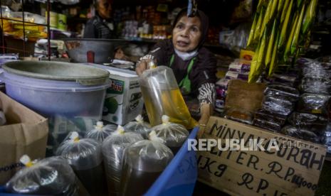 Pedagang merapikan minyak goreng curah yang dijual di Pasar Kramat Jati, Jakarta, Sabtu (25/6/2022). Menteri Koordinator Bidang Kemaritiman dan Investasi Luhut Binsar Pandjaitan berencana merubah sistem penjualan dan pembelian minyak goreng curah rakyat (MGCR) dengan menggunakan aplikasi PeduliLindungi atau menunjukan NIK yang akan mulai disosialisasikan pada Senin (27/6/2022). Republika/Putra M. Akbar