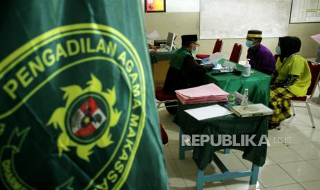 Pasangan pengantin mengikuti sidang isbat pernikahan yang dilaksanakan secara massal di SMP Negeri 13 Makassar, Sulawesi Selatan, Rabu (2/11/2020). Sebanyak 413 pasangan pengantin mengikuti sidang isbat pernikahan massal yang diadakan oleh Dinas Sosial Makassar dalam rangka memperingati hari jadi Kota Makassar ke-413 dengan menerapkan protokol kesehatan guna mencegah penularan COVID-19. 