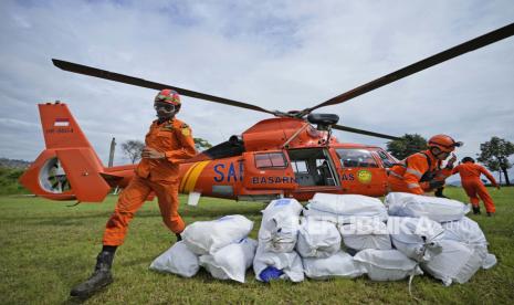  Anggota Badan Pencarian dan Pertolongan Nasional (BASARNAS) menggunakan helikopter untuk mengantarkan barang-barang bantuan ke desa yang terkena dampak gempa Senin di Cianjur, Jawa Barat, Indonesia, Sabtu, 26 November 2022. Gempa bermagnitudo 5,6 menewaskan ratusan orang, banyak dari mereka adalah anak-anak, dan membuat puluhan ribu orang mengungsi.