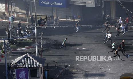 Warga Palestinian berlarian di jalan saat bentrok dengan militer Israel di Jenin, Tepi Barat, 4 Juli 2023. 