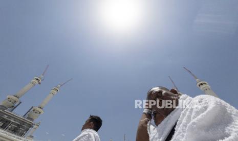 Umat Islam menutup kepalanya dari terik matahari seusai seusai berlangsung peristiwa Rashdul Qiblah atau waktu matahari tepat di atas Ka bah.