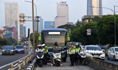 Polisi menilang pengendara yang menerobos jalur Bus TransJakarta di Jalan Gatot Subroto, Jakarta, Rabu (19/6/2024). Korlantas Polri dalam kurun awal tahun 2024 hingga 14 Mei 2024 telah menindak 564.838 pelanggar lalu lintas melalui sistem tilang manual dan tilang elektronik atau Electronic Traffic Law Enforcement (ETLE).