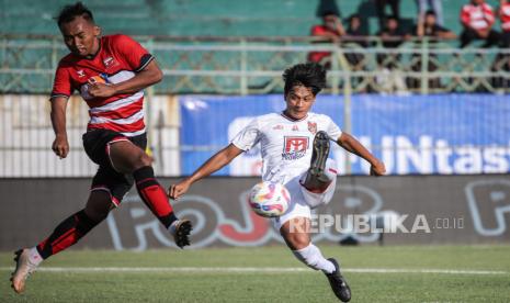 Pesepak bola Malut United Pramoedya Putra Suhardi (kanan) menendang bola dengan dihadang pesepak bola Madura United Nur Diansyah (kiri) pada pertandingan BRI Liga 1 di Stadion Gelora Bangkalan, Bangkalan, Jawa Timur, Sabtu (10/8/2024). Pertandingan berakhir imbang dengan skor 1-1. 