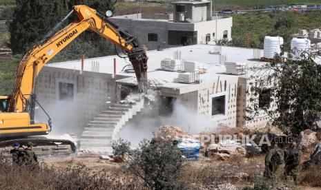 Tentara Israel berjaga-jaga saat buldoser militer menghancurkan sebuah rumah Palestina di kota Hebron, Tepi Barat, 03 Oktober 2022. Menurut pihak berwenang Israel, rumah itu dihancurkan karena dibangun tanpa izin.