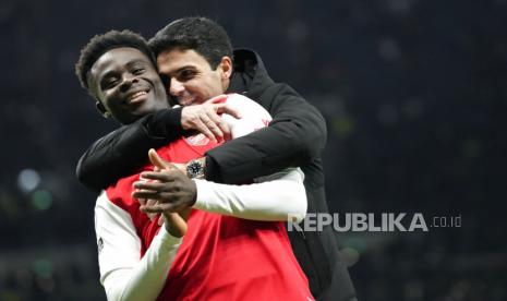 Pemain Arsenal Bukayo Saka dan manajer Arsenal Mikel Arteta merayakan kemenangan mereka pada pertandingan sepak bola Liga Premier Inggris antara Tottenham Hotspur dan Arsenal di Stadion Tottenham Hotspur di London, Inggris, Ahad, 15 Januari 2023.