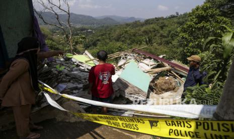 Warga mengamati rumah hancur di Tegalkaso, Desa Bencoy, Cireunghas, Kabupaten Sukabumi, Jawa Barat, Sabtu (2/12/2023). Badan Penanggulangan Bencana Daerah (BPBD) Kabupaten Sukabumi mencatat akibat pergeseran tanah sedikitnya lima rumah warga rusak, akses jalan penghubung antar kampung retak dan sebanyak 21 warga terpaksa mengungsi di tempat yang aman. 