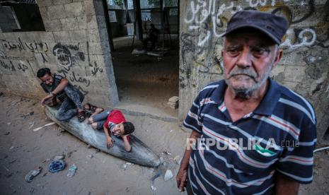 Warga Palestina terlihat di sekitar rudal yang tidak meledak yang ditembakkan oleh pesawat tempur Israel, setelah serangan udara Israel, di Kota Gaza, 19 Mei 2021. 