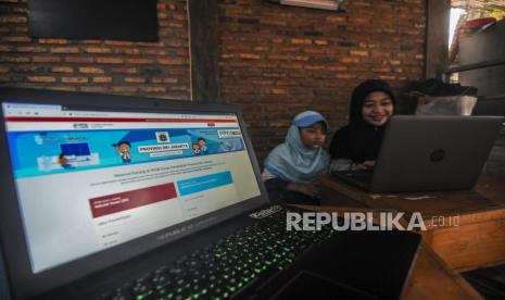 Orang tua murid bersama anaknya saat melakukan Pendaftaran Penerimaan Peserta Didik Baru (PPDB) secara online. ilustrasi