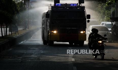 Kepolisian menyemprotkan disinfektan dengan menggunakan mobil water canon (ilustrasi).