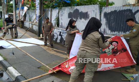 Petugas Satpol PP bersama Badan Pengawas Pemilihan Umum (Bawaslu) Bandung Wetan menertibkan Alat Peraga Kampanye (APK) yang melanggar aturan di Jalan Dipenogoro, Kota Bandung, Senin (22/1/2024). Penertiban tersebut merupakan upaya dalam menjaga estetika, keindahan, ketertiban dan keamanan Kota Bandung.