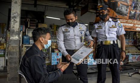 Calon penumpang memindai kode batang melalui aplikasi PeduliLindungi sebelum menaiki bus di Terminal Cicaheum, Kota Bandung, Senin (28/3/2022). Dishub Kota Bandung mengecek kelaikan jalan dan operasi angkutan mudik.