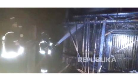 Petugas pemadam kebakaran Kabupaten Kuningan sedang melakukan pendinginan terhadap kandang ayam yang terbakar di Desa Karangsari. Akibat kebakaran itu, 2.000 ekor ayam mati terpanggang. 