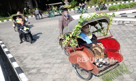 Perwakilan wisudawan Universitas Sebelas Maret (UNS) mengendarai transportasi ramah lingkungan saat mengikuti prosesi acara Wisuda Luring dan Daring secara Drive Thru di kampus setempat, Solo, Jawa Tengah, Sabtu (27/6/2020). Wisuda dengan konsep drive thru tersebut digelar UNS sebagai bentuk kreatifitas adaptasi kampus setempat dalam situasi normal baru ditengah Pandemi COVID-19. 