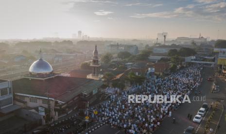 Foto aerial jemaah melaksanakan shalat Idul Fitri 1 Syawal 1441 Hijriyah di jalan raya area Masjid Jami An-Nur, Kranji, Bekasi, Jawa Barat, Ahad (24/5). Pelaksanaan shalat Idul Fitri tersebut dilakukan dengan menerapkan protokol kesehatan seperti menggunakan masker serta menjaga jarak fisik guna mengurangi resiko terpapar virus corona atau COVID-19