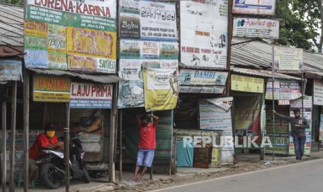 Sejumlah pegawai agen bus menanti penumpang yang ingin memesan tiket di Jalan Raya Bogor, Cimanggis, Depok, Jawa Barat, Senin (4/5/2020). Agen tiket bus mengaku semenjak diberlakukannya larangan mudik mengakibatkan sepinya penumpang sehingga beberapa agen tutup