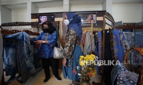 Pengunjung mengamati produk pada pameran ekonomi kreatif sub sektor kriya batik di loby kantor TVRI Yogyakarta, Rabu (19/01/2022). Pameran yang digagas oleh Dinas Pariwisata Sleman itu menampilkan berbagai produk batik, tenun serta printing dari belasan IKM Sleman  guna mengeliatkan sektor pariwisata khususnya ekonomi kreatif itu berlangsung hingga 31 Januari 2022. 