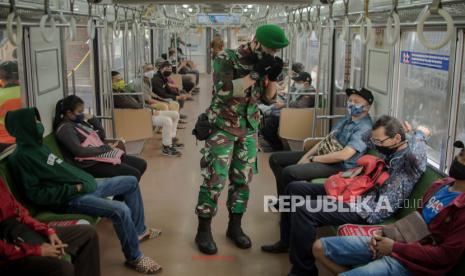 Petugas TNI mengimbau penumpang Kereta Rel Listrik untuk menggunakan masker dengan benar di Stasiun Tanah Abang, Jakarta. 